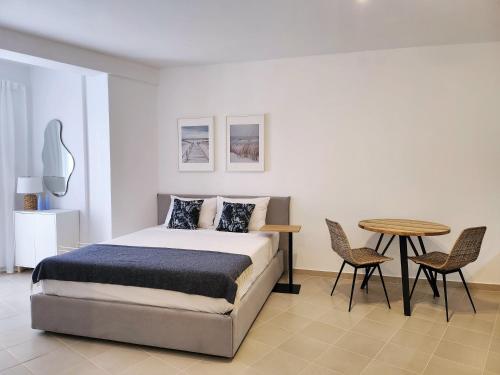 een slaapkamer met een bed en een tafel en stoelen bij ELISOS Studio Apartment with swimming pool in Vlorë