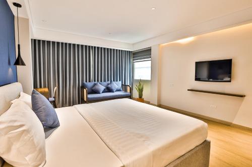 um quarto com uma cama grande e uma televisão em La Paix Sài Gòn - Boutique Hotel em Ho Chi Minh