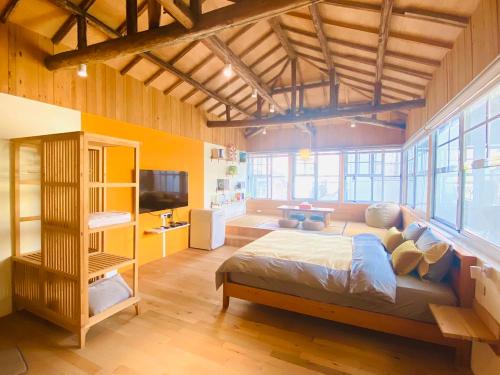 a bedroom with a large bed in a room with windows at Meet Forty Homestay in Tainan