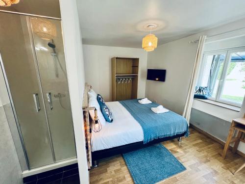 a bedroom with a bed and a walk in shower at "Villa du Circuit" avec Piscine, 4 Chambres, 4 SDB, à 8 min du circuit, parking et portail électrique in Mars-sur-Allier