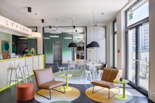 un restaurant avec des tables, des chaises et un comptoir dans l'établissement LyvInn Hotel Frankfurt Messe, à Francfort-sur-le-Main