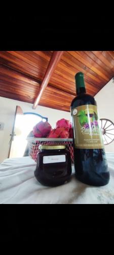 a bottle of soap and a basket of flowers on a bed at Casa de Campo- no bosque c lareira elétrica in Jarinu