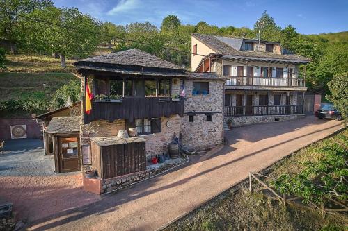 une vieille maison avec un drapeau devant elle dans l'établissement O Palleiro do Pe do Forno, à Orellán