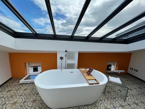 eine große weiße Badewanne in einem Zimmer mit einer Decke in der Unterkunft La casa di Nonna Patti e Andy in Gardone Riviera