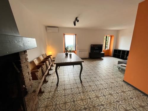 ein Wohnzimmer mit einem Tisch und einem Kamin in der Unterkunft La casa di Nonna Patti e Andy in Gardone Riviera