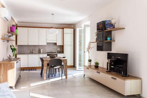 a kitchen with white cabinets and a table with a microwave at Celia’s House in Lezzeno