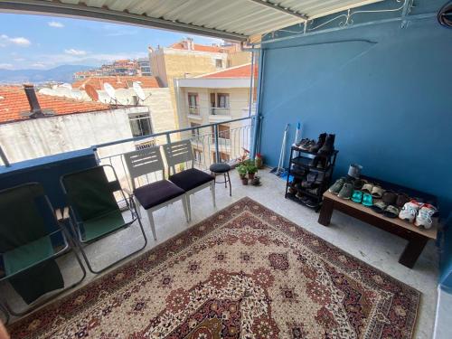a balcony with a rug and chairs and a view of a city at gezginin odası in İzmir