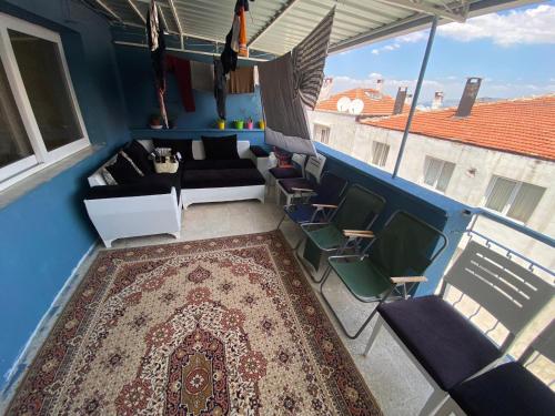 a balcony with a couch and chairs and a rug at gezginin odası in İzmir