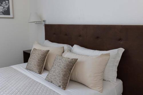 a bed with a bunch of pillows on it at Liberty Palace in Milazzo