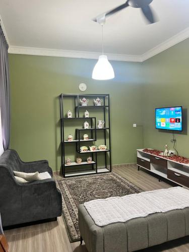 sala de estar con sofá y TV en Kubu Gajah Homestay, 15 Minutes to Subang Airport, en Sungai Buloh