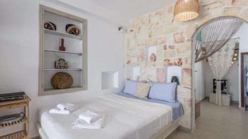 a bedroom with a bed and a stone wall at Klima On The Waterfront in Klima