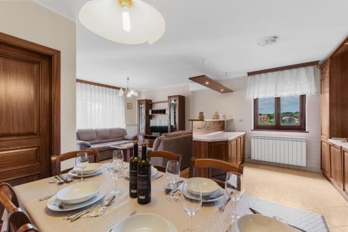 a dining room and kitchen with a table with wine glasses at Apartment Luma in Vižinada