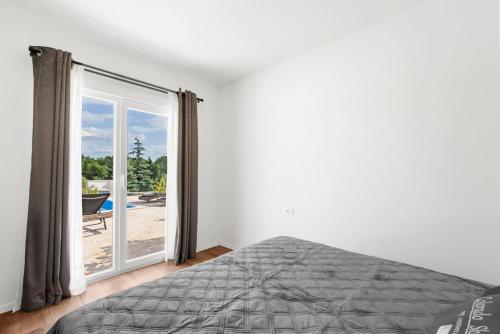 sypialnia z łóżkiem i przesuwnymi szklanymi drzwiami w obiekcie Casa Cosini with Private Pool w Poreču