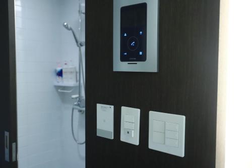 porta del bagno con telefono appeso al muro di Shine residence a Incheon