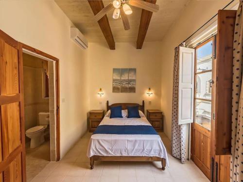 1 dormitorio con 1 cama y ventilador de techo en Traditional farmhouse with pool, en Xagħra