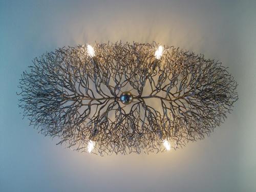 a chandelier made out of branches with lights at Business Wieland Hotel in Düsseldorf