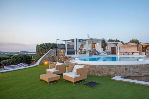 a backyard with a swimming pool and a house at Villabellum Mykonos in Mýkonos City