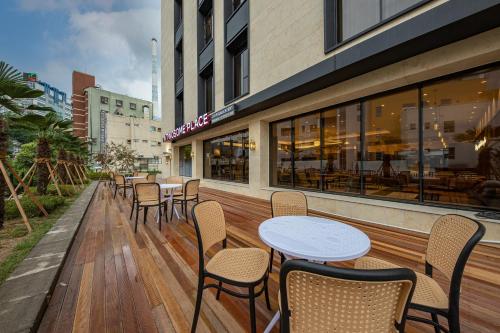 a restaurant with tables and chairs on a wooden deck at Masan Daisy Hotel in Changwon