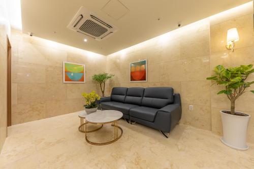 a living room with a couch and a table at Masan Daisy Hotel in Changwon