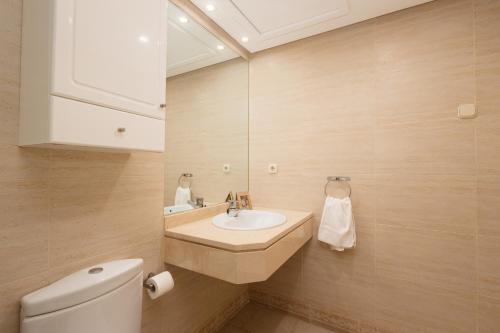 łazienka z umywalką, toaletą i lustrem w obiekcie Sea view apartment in the center of puerto Banús and private parking w Marbelli