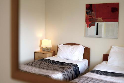 a bedroom with two beds and a mirror at Long Quay Apartments, Clonakilty in Clonakilty