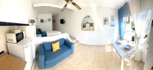 a living room with a blue couch and a bedroom at New! Seaview-Vistas al Mar con Piscina en La Pineda in La Pineda