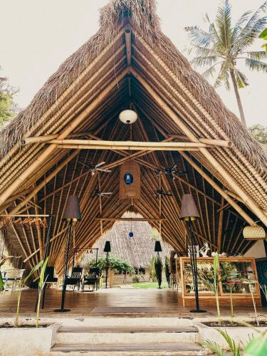 a large building with a thatched roof at Vayam Boutique Resort Gili Asahan in Gili Asahan