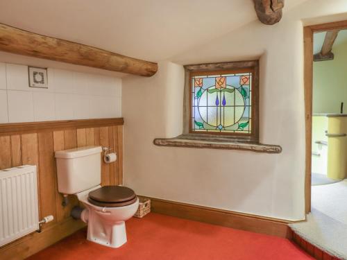 a bathroom with a toilet and a stained glass window at Old Bar House in Keighley