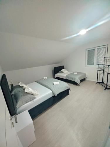 - une chambre avec 2 lits et une fenêtre dans l'établissement Apartman Christina, à Bilice
