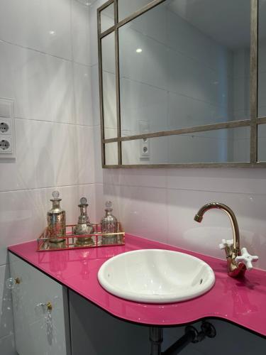 a bathroom with a sink and a mirror on a pink counter at DÚPLEX DE LUJO EN FOZ CON VISTAS al MAR in Foz