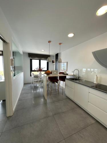 a kitchen and dining room with a table and chairs at DÚPLEX DE LUJO EN FOZ CON VISTAS al MAR in Foz