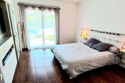 1 dormitorio con cama y ventana grande en Villa 140 m² hab. avec piscine, en Castres