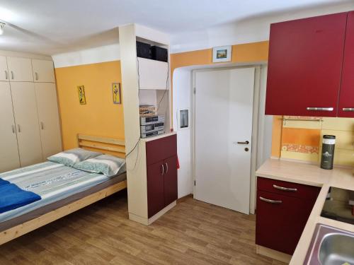 Kleines Zimmer mit einem Bett und einer Küche in der Unterkunft Studio Lotrist in Radovljica