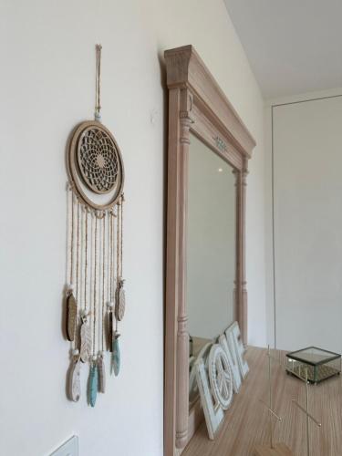 a dream catcher hanging on a wall next to a mirror at DÚPLEX DE LUJO EN FOZ CON VISTAS al MAR in Foz