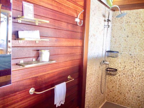 bagno con pareti in legno e doccia con lavandino di Le Karbé Bakov a Rémire-Camp
