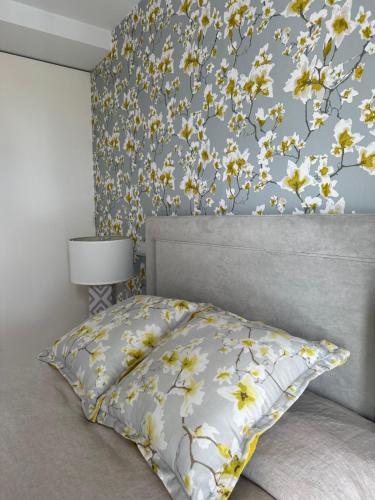 a bedroom with a bed with a floral wall at DÚPLEX DE LUJO EN FOZ CON VISTAS al MAR in Foz