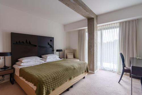 a bedroom with a large bed and a large window at Hotel Palisad in Zlatibor