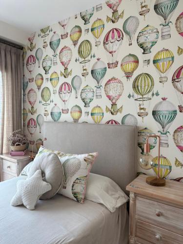 a bedroom with a wallpaper of hot air balloons at DÚPLEX DE LUJO EN FOZ CON VISTAS al MAR in Foz