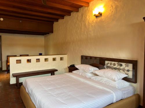 a bedroom with a large bed with white sheets at The Kaptain's Retreat in Chandīgarh