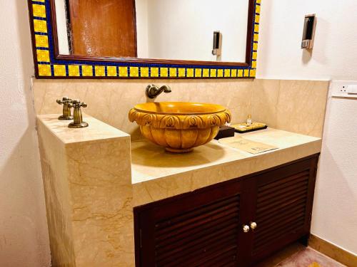 a bathroom with a bowl sink and a mirror at The Kaptain's Retreat in Chandīgarh