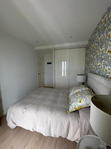 a bedroom with a large bed with a wall at DÚPLEX DE LUJO EN FOZ CON VISTAS al MAR in Foz