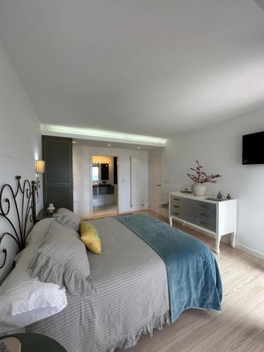 a bedroom with a large bed and a dresser at DÚPLEX DE LUJO EN FOZ CON VISTAS al MAR in Foz