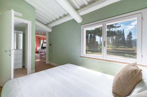 a bedroom with a white bed and a window at Le Versegge Resort in Braccagni