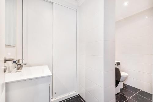 biała łazienka z toaletą i umywalką w obiekcie Ria Mar Deluxe - City Center @Homesbyfc w Faro