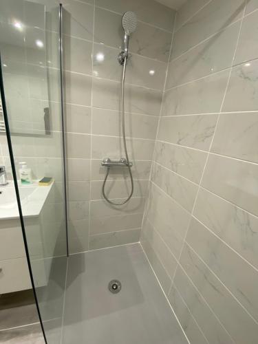 une douche avec une porte vitrée dans une salle de bain dans l'établissement Superbe appartement centre ville chez Tony, à Périgueux