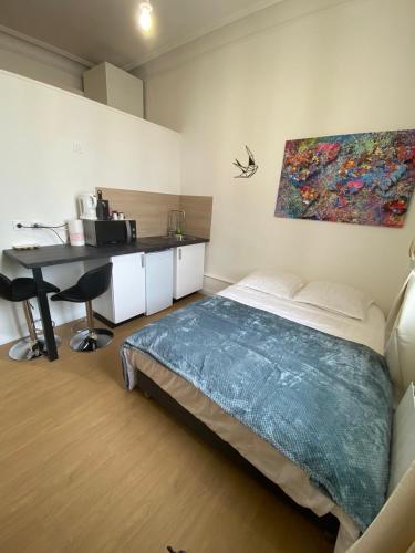 une chambre avec un lit, un bureau et un tableau dans l'établissement Superbe appartement centre ville chez Tony, à Périgueux