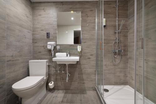 a bathroom with a shower and a toilet and a sink at Prague Season Hotel in Prague