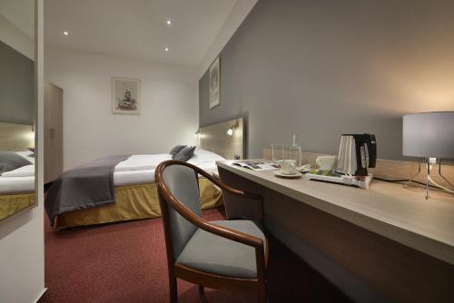 a hotel room with a desk and a bed at Prague Season Hotel in Prague