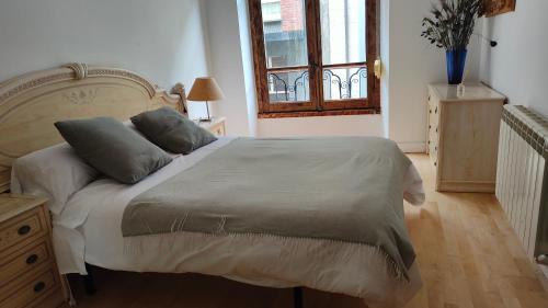 um quarto com uma cama com duas almofadas em LAS LETRONAS em Gijón