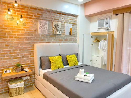 a bed in a room with a brick wall at Lovely Unit with free wi-fi & netflix I across Naia T3 airport in Manila